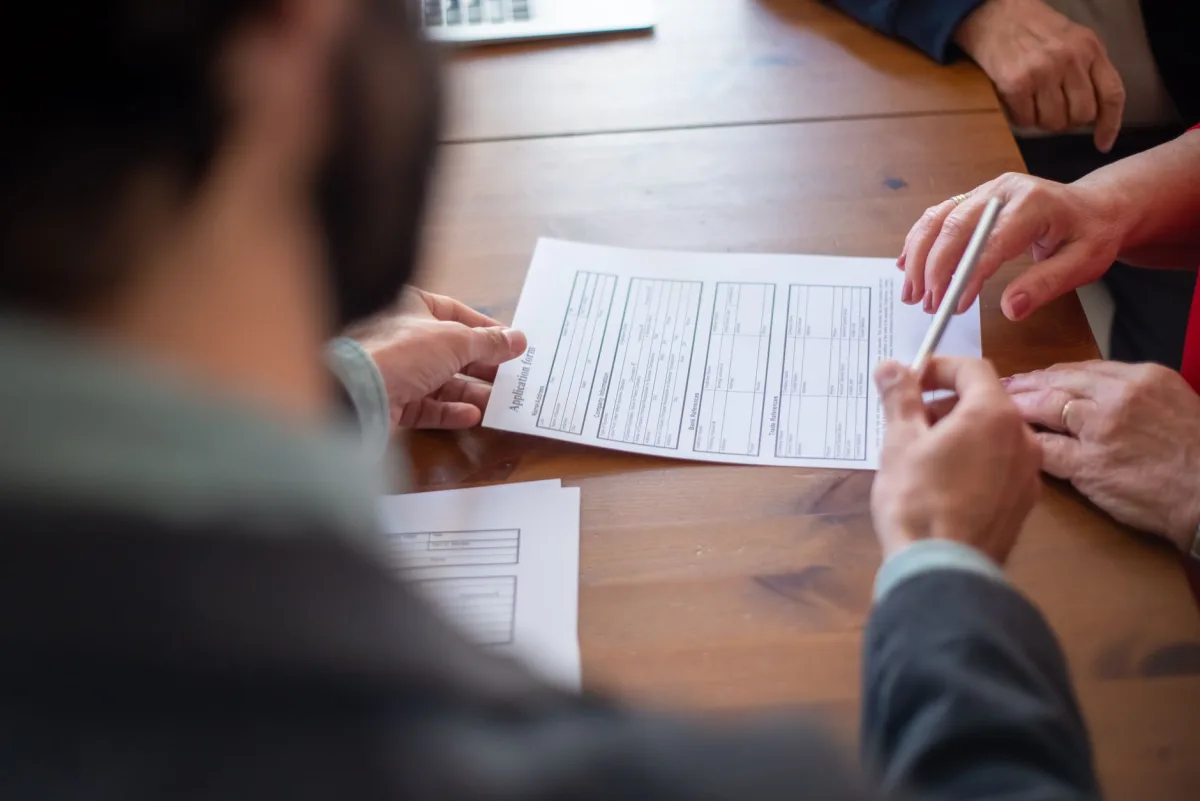 Close-up of business professionals reviewing documents at a meeting. Close-up of business professionals reviewing documents at a meeting.