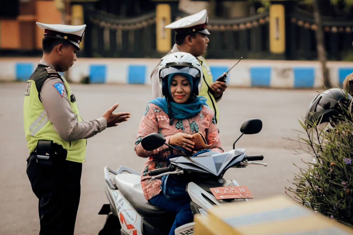 A motorcyclist converses with police officers in Bangkalan, East Java, Indonesia. A motorcyclist converses with police officers in Bangkalan, East Java, Indonesia.