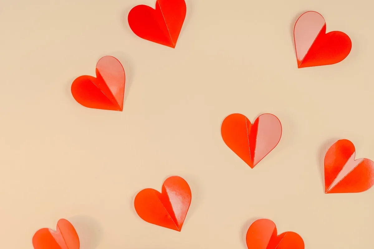 Artistic arrangement of red paper hearts creates a romantic mood.
