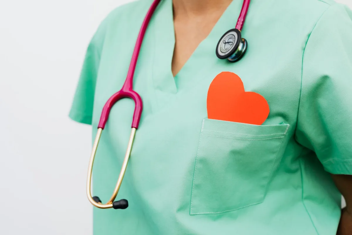 A healthcare professional a stethoscope and red symbol emphasizes cardiology care.