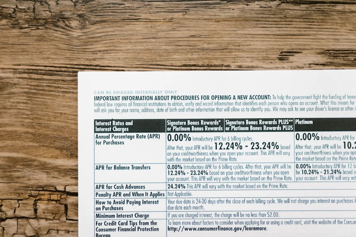 A detailed financial document listing interest rates on a textured wooden table. A detailed financial document listing interest rates on a textured wooden table.