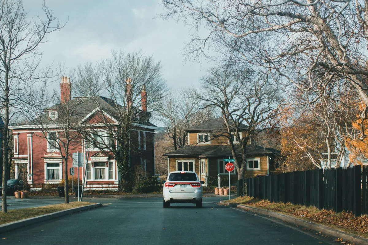 A scenic suburban street with vibrant autumn foliage and traditional houses. A scenic suburban street with vibrant autumn foliage and traditional houses.