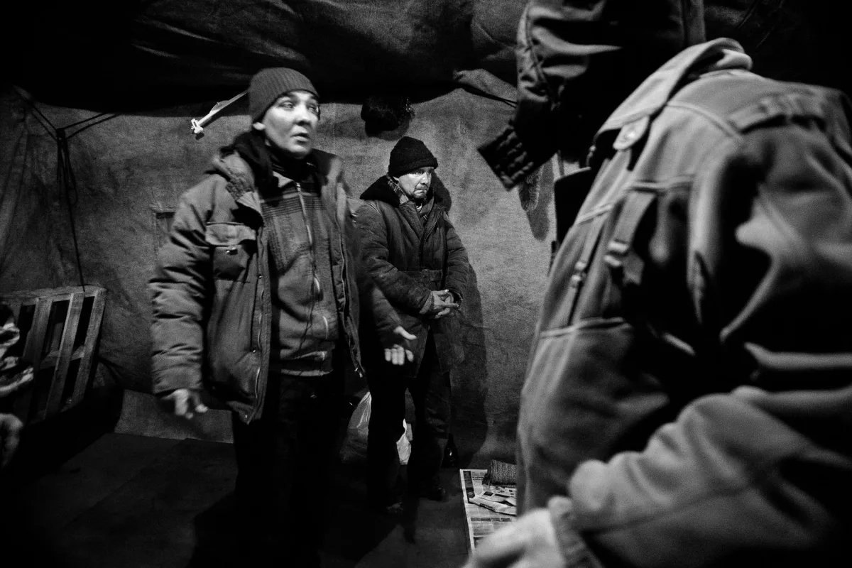 Black and white of men in outerwear in shelter for homeless people in poverty