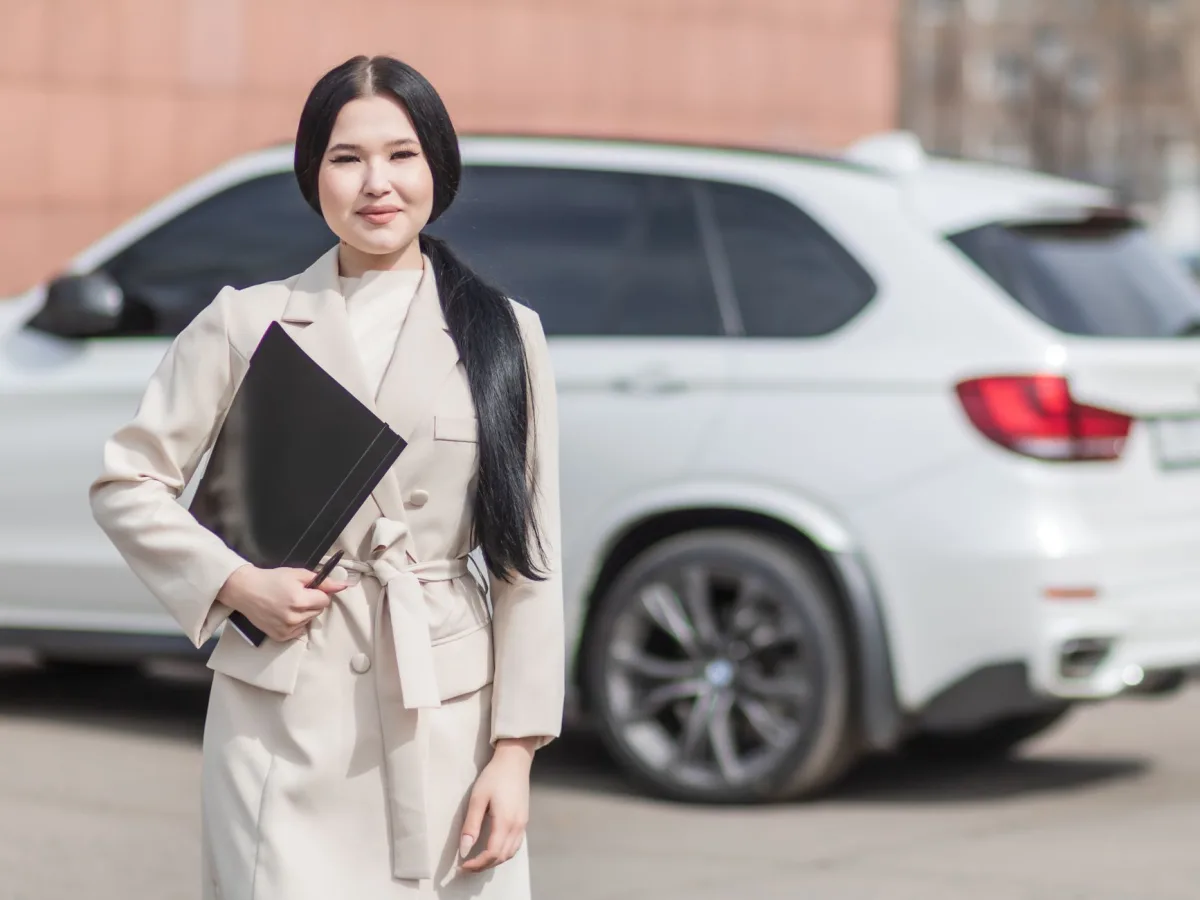 Smiling professional woman standing confidently by a luxury embodying success.
