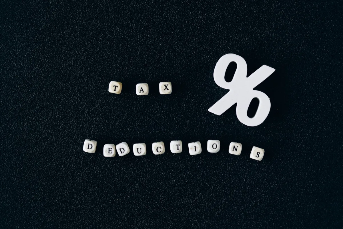 Conceptual image of deductions with alphabet blocks and percent symbol on black surface. Conceptual image of deductions with alphabet blocks and percent symbol on black surface.
