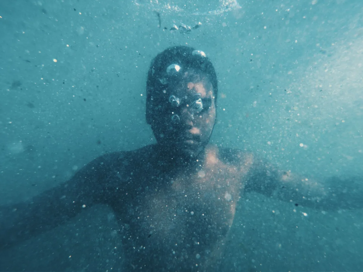 A dramatic underwater portrait capturing the solitude of a male diver. A dramatic underwater portrait capturing the solitude of a male diver.
